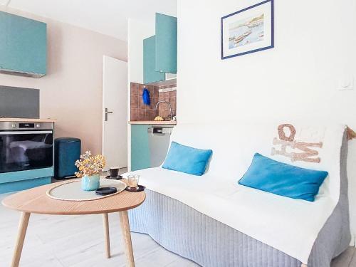 Cette chambre comprend un lit avec des oreillers bleus et une table. dans l'établissement Apartment le Verdon-5 by Interhome, à Six-Fours-les-Plages