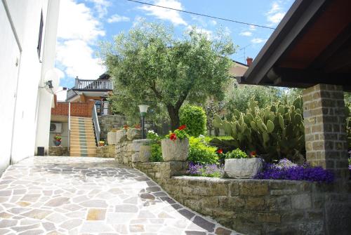 a garden with flowers and a stone walkway at Guest House Nena in Motovun