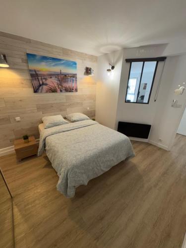 une chambre avec un lit et un tableau au mur dans l'établissement Appartement 40 m2 climatisé au centre ville de LGM, à La Grande Motte