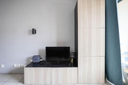 une pièce avec un bureau et une télévision dans un mur dans l'établissement Le Cannes Beach 302, à Cannes