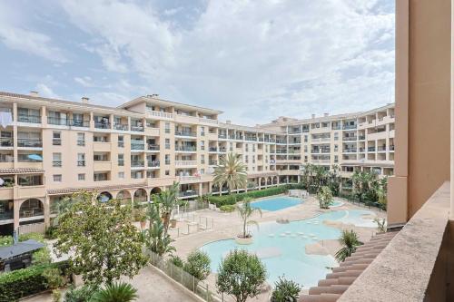 un immeuble d'appartements avec piscine et palmiers dans l'établissement Le Cannes Beach 302, à Cannes