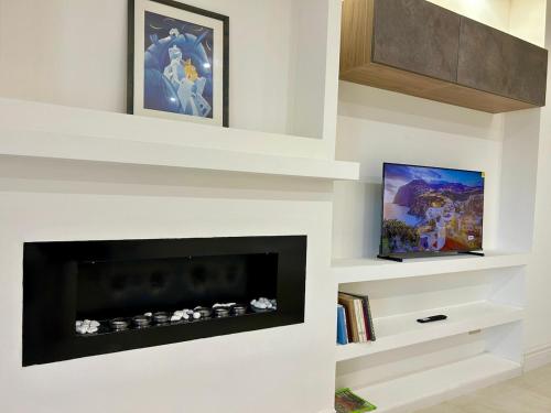 a living room with a fireplace and a tv at Comfort & design - 20' dalle terme di Saturnia in Manciano