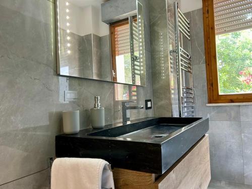 a bathroom with a black sink and a window at Comfort & design - 20' dalle terme di Saturnia in Manciano
