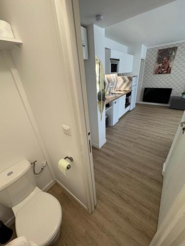 La salle de bains blanche est pourvue de toilettes et d'un couloir. dans l'établissement Appartement 40 m2 climatisé au centre ville de LGM, à La Grande Motte