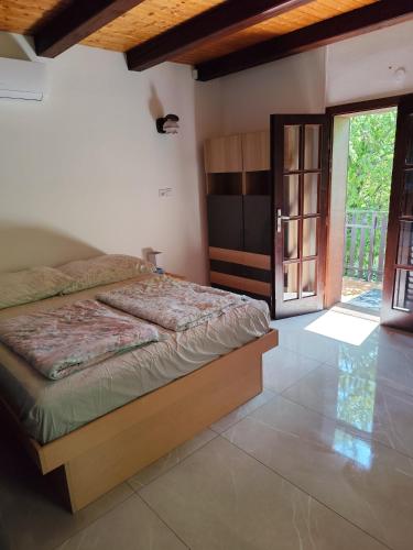 a bedroom with a bed and a door to a patio at Balassa Weekendhouse in Siófok