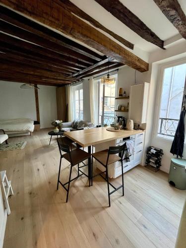 une cuisine avec une table et des chaises dans une pièce dans l'établissement Appartement en centre ville de Versailles, à Versailles