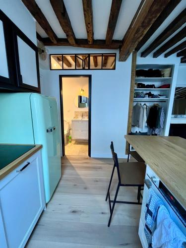 Il comprend une cuisine équipée d'un réfrigérateur et d'une table. dans l'établissement Appartement en centre ville de Versailles, à Versailles