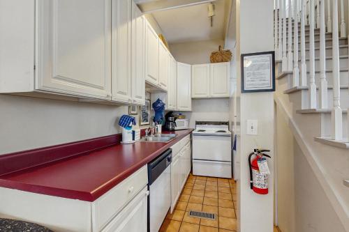 a small kitchen with white cabinets and a sink at 4 Bee St in Charleston