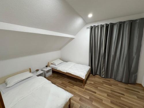a small room with two beds and a window at Villa Nature Konjic in Konjic