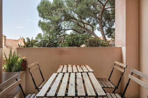 - une table en bois et 2 chaises sur la terrasse dans l'établissement Le Cannes Beach 293, à Cannes