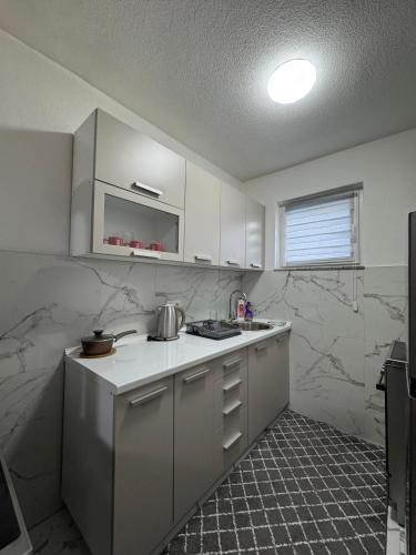a kitchen with white appliances and marble walls at Villa Nature Konjic in Konjic