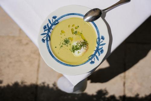 a bowl of broccoli soup with a spoon in it at Relais de Chambord, a Small Luxury Hotels of the World in Chambord