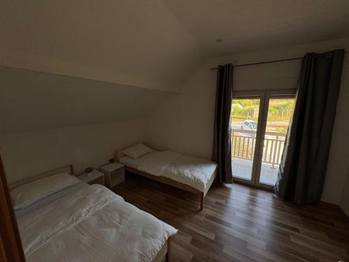 a bedroom with two beds and a large window at Villa Nature Konjic in Konjic