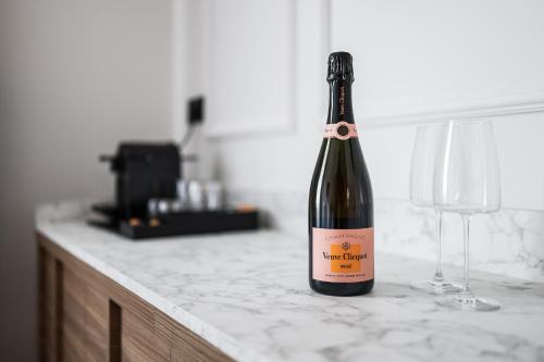 eine Flasche Wein mit zwei Gläsern auf einer Theke in der Unterkunft Estium Heritage Rooms in Zadar