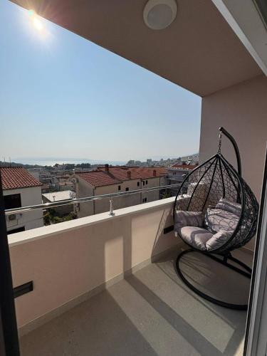 a swing on a balcony with a view of a city at Apartment Lana in Makarska