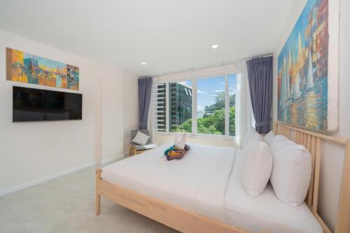 芭东海滩Private sea view apartment with jacuzzi at Baycliff的一间带大床的卧室，带窗户