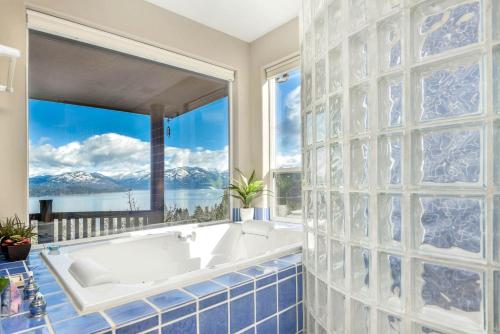 a bath tub in a bathroom with a large window at Majestic Summit Retreat: Family Vacation Rental Overlooking Lake Pend Oreille in Lignite