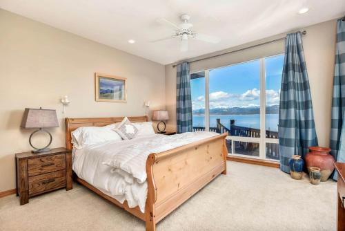 a bedroom with a bed and a large window at Majestic Summit Retreat: Family Vacation Rental Overlooking Lake Pend Oreille in Lignite