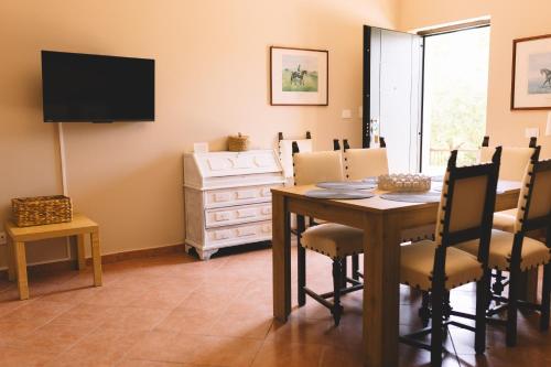 a dining room with a table and chairs and a television at Tenuta di Vico Moricino in Anagni