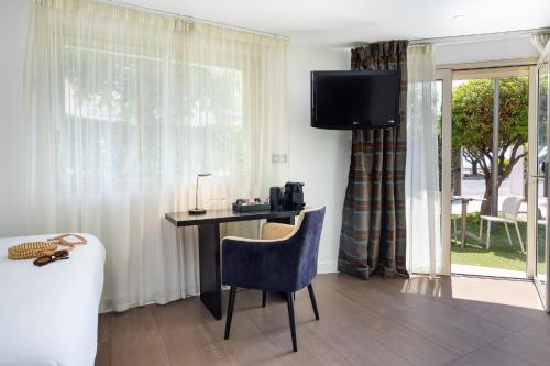 a desk with a chair in a room with a window at Hotel Royalmar - Nouveau propriétaire in Cagnes-sur-Mer