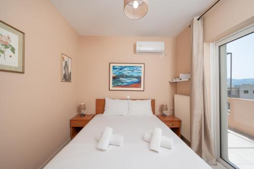 a bedroom with a bed and a window at Villa Clotho in Porto Rafti