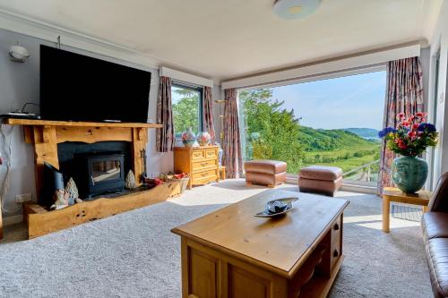 a living room with a fireplace and a television at 5 bed house near Oban in Oban