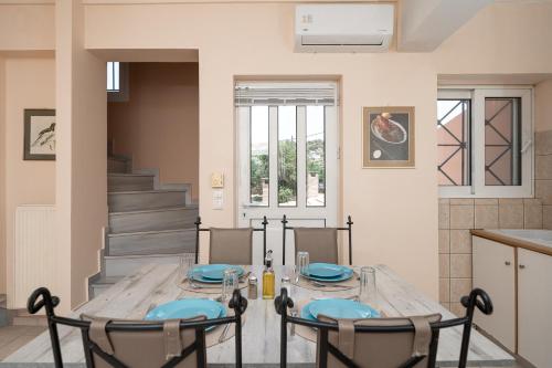 a dining room with a wooden table and chairs at Villa Clotho in Porto Rafti