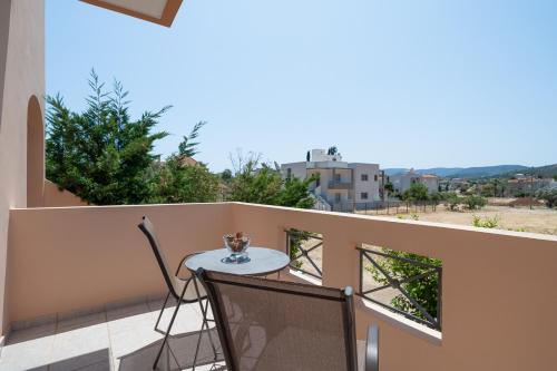 a table and chairs on a balcony with a view at Villa Clotho in Porto Rafti