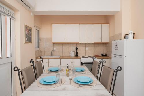 a kitchen with a table with chairs and a white refrigerator at Villa Clotho in Porto Rafti