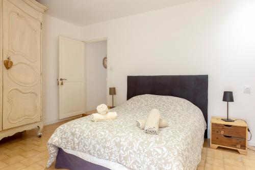 a bedroom with a bed with two towels on it at Le Patio des Salins - Sublime maison de charme intramuros à Aigues-Mortes in Aigues-Mortes