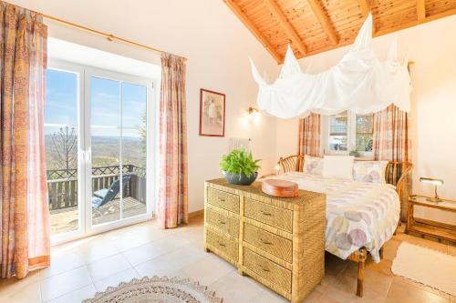 a bedroom with a bed and a large window at CASA PAVÃO (SALGADINHO - SELÃO DA EIRA) in São Teotónio