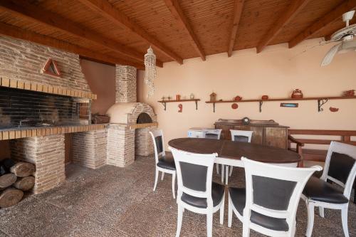a dining room with a table and a fireplace at Villa Clotho in Porto Rafti
