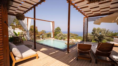 a house with a swimming pool on a wooden deck at Lov Faralya Adults Only in Faralya