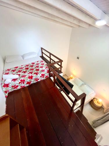 a bedroom with a bed with a red and white blanket at Pousada Tô na Praia Juquehy in Juquei