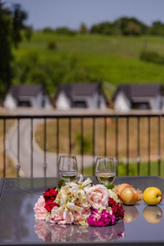 a table with two wine glasses and flowers on it at Plitvice Nature Residence in Rastovača