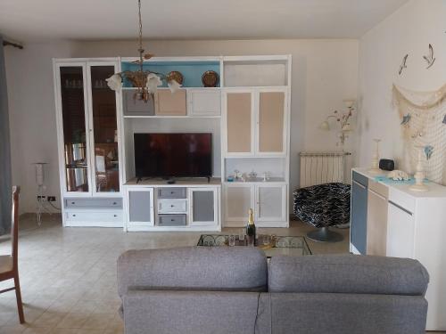 a living room with a couch and a tv at Villa Ornella in Luni