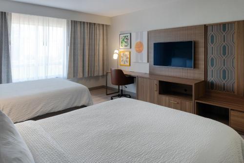 a hotel room with two beds and a flat screen tv at Holiday Inn Rock Hill by IHG in Rock Hill