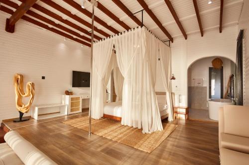 a bedroom with a bed with curtains in a room at Lov Faralya Adults Only in Faralya