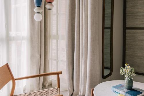 a room with a table and a window with curtains at Les Bassans in Perros-Guirec