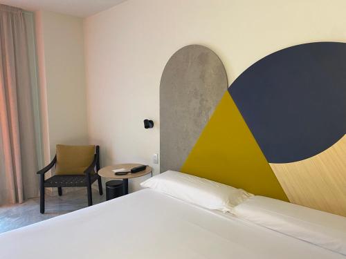 a hotel room with a bed and a chair at Onix Fira in Barcelona