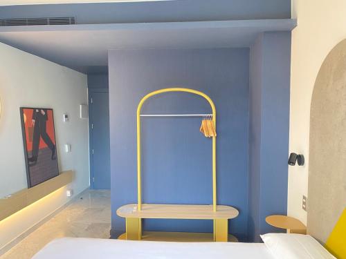 a bedroom with a blue wall and a yellow chair at Onix Fira in Barcelona