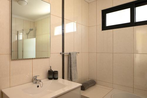 ein weißes Badezimmer mit Waschbecken und Spiegel in der Unterkunft Casa Pimenta in Fajã da Ovelha in Prazeres