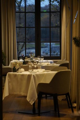 a dining room with two tables and a large window at Relais de Chambord, a Small Luxury Hotels of the World in Chambord