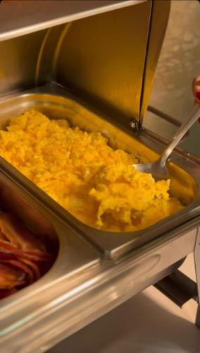 a pan of food in an oven with a spatula at Hotel e Restaurante Santa Isabel in São Raimundo Nonato