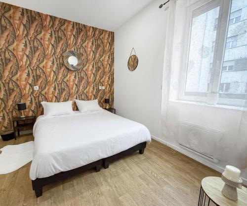a bedroom with a bed and a large window at Charmant studio rénové à Roubaix in Roubaix