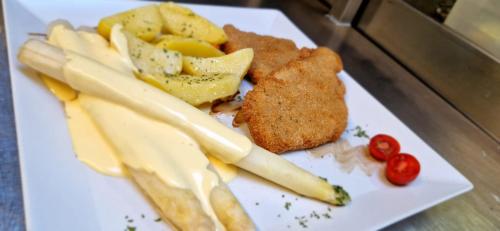 a plate of food with meat and cheese and vegetables at Landhotel Eifelblick in Stadtkyll