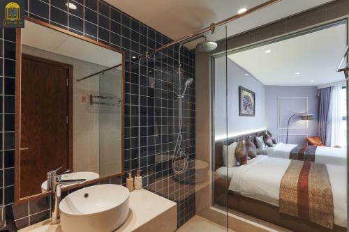 a bathroom with a bed and a sink and a mirror at Apec Mandala Wyndham Mui Ne Ngoc Linh in Mui Ne