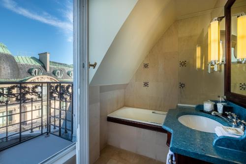 a bathroom with a tub and a sink and a window at Hôtel Pont Royal Paris in Paris