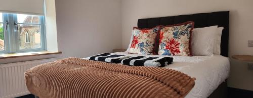 a bedroom with a bed with a black headboard and pillows at 2 High Silver House in Holt