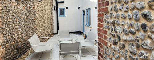 a room with chairs and a brick wall at 2 High Silver House in Holt